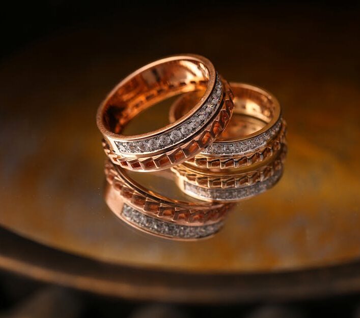 Close-up of luxury gold and diamond wedding rings reflecting light beautifully.