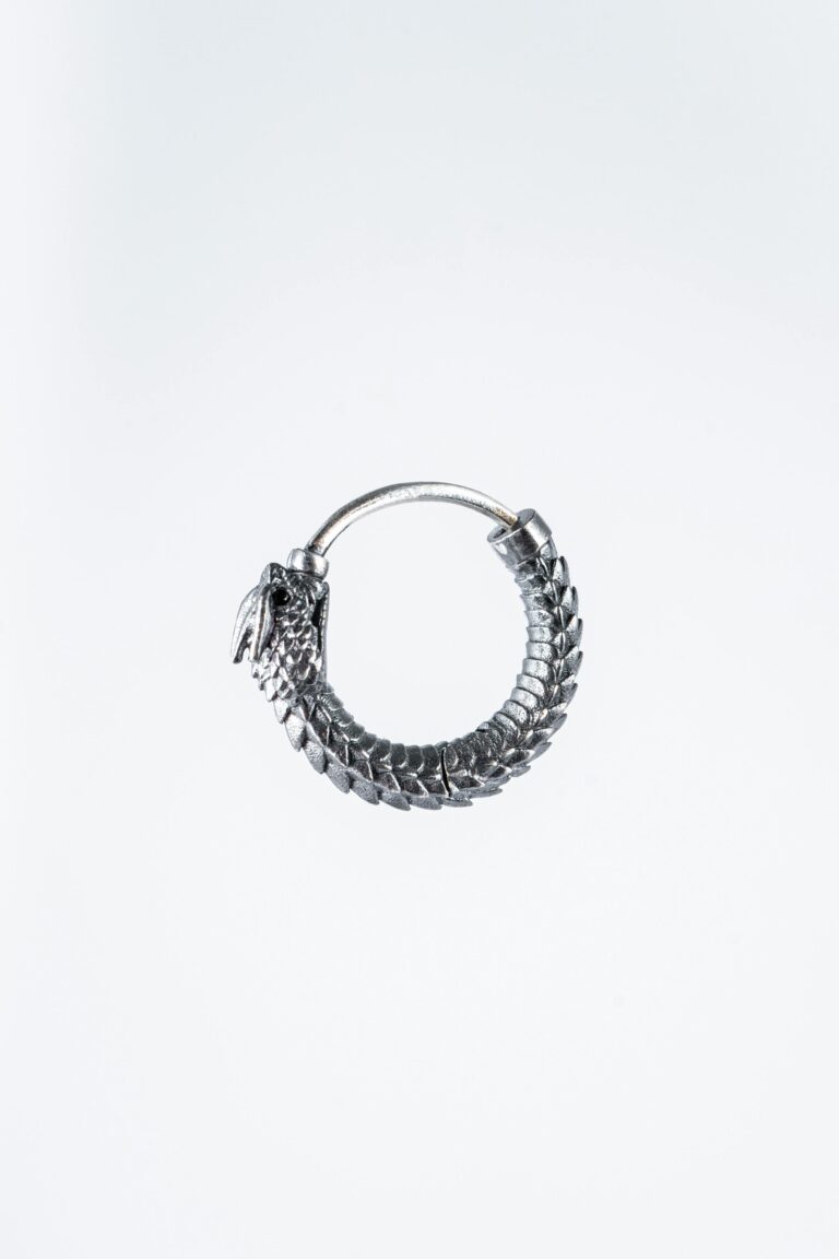 His Highness Silver Ouroboros snake earring symbolizing eternity against a sleek white backdrop.